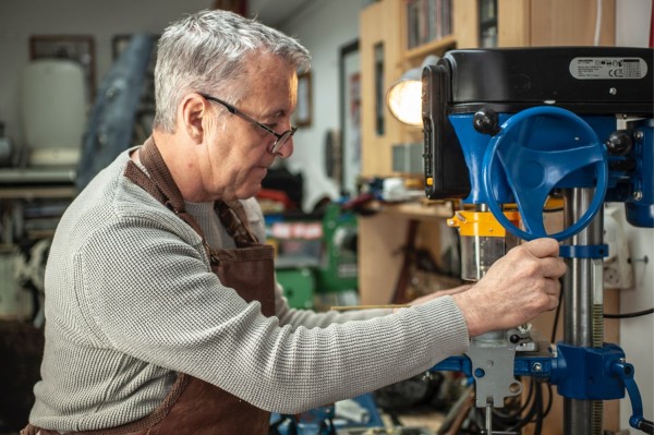 Sean Morrissey is using a drill press