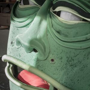 A close up portrait of a green big monster head