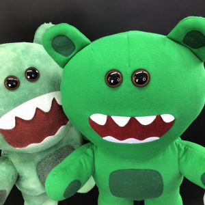 2 green puppets standing with black background