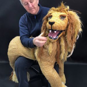 Sean with a lion puppet on his lap.