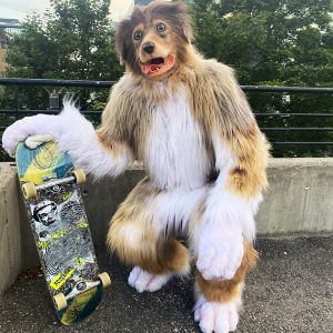 A person in dog costume holds a skateboard